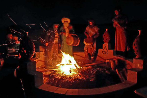 Drumming around the campfire in the camp