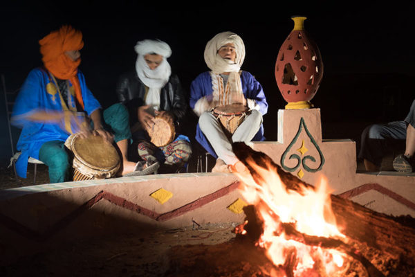 Drumming by the fire in the camp